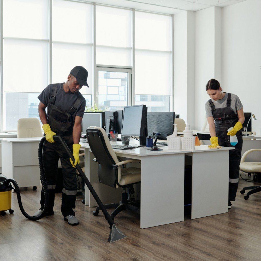 Team cleaning workspace surfaces